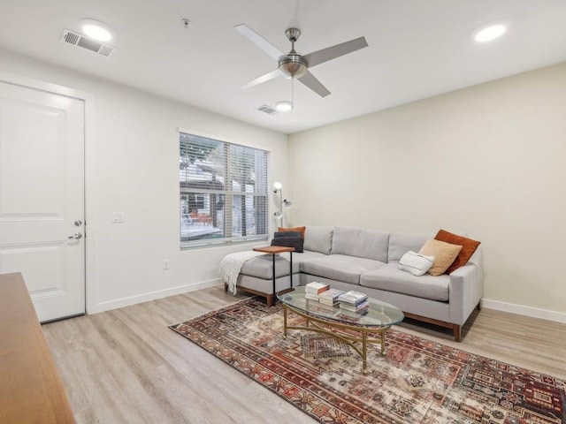 living room with light wood-type flooring and ceiling fan