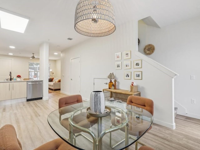 dining room with light hardwood / wood-style flooring, ceiling fan, and sink