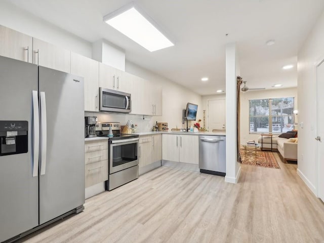 kitchen with light hardwood / wood-style floors, sink, and appliances with stainless steel finishes