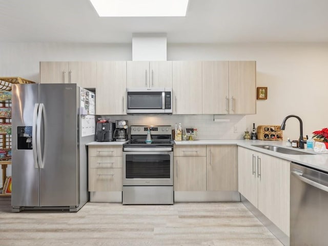 kitchen with tasteful backsplash, sink, stainless steel appliances, and light brown cabinets