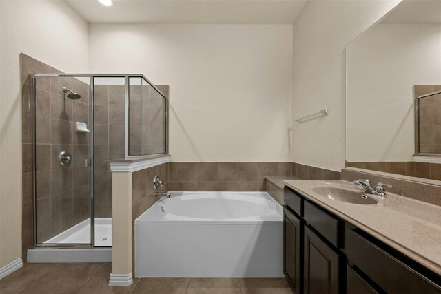 bathroom with tile patterned flooring, vanity, and separate shower and tub