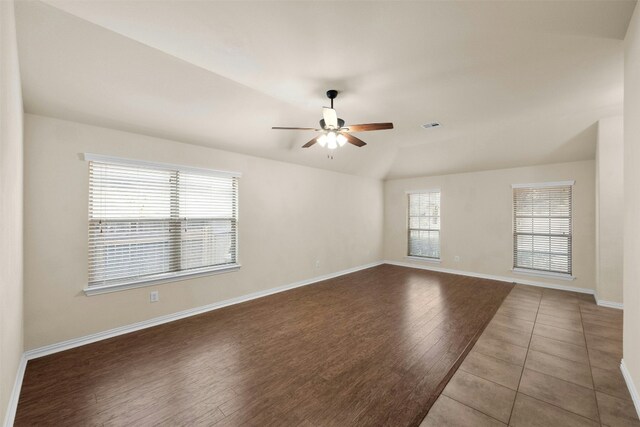 empty room featuring hardwood / wood-style flooring, ceiling fan, and vaulted ceiling