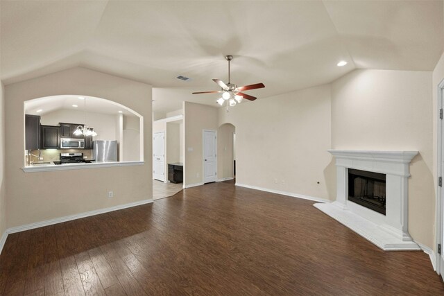 unfurnished living room with lofted ceiling, sink, dark wood-type flooring, and ceiling fan with notable chandelier