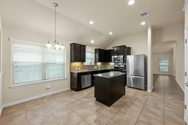 kitchen with a kitchen island, lofted ceiling, stainless steel appliances, and a wealth of natural light