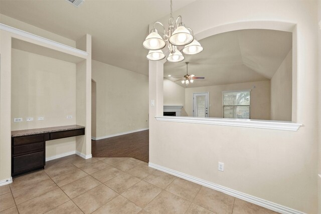 interior space featuring ceiling fan with notable chandelier and vaulted ceiling