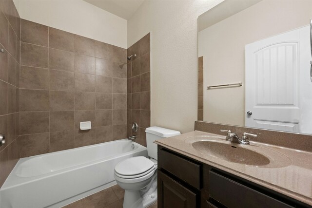 full bathroom with vanity, tiled shower / bath combo, tile patterned floors, and toilet