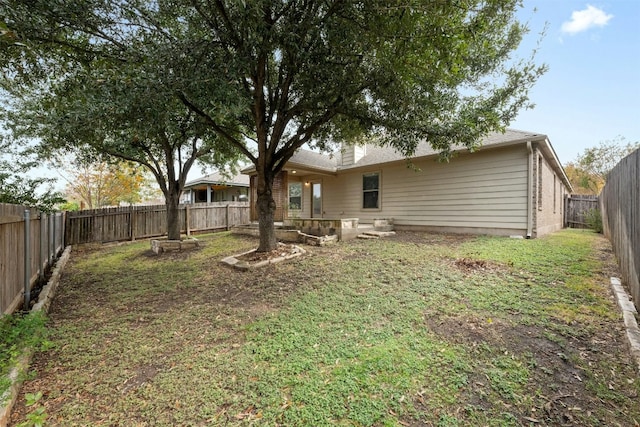 rear view of property featuring a lawn