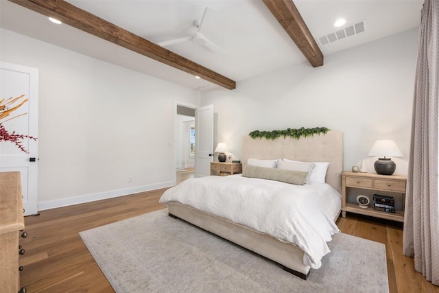 bedroom featuring ceiling fan, beamed ceiling, and dark hardwood / wood-style floors