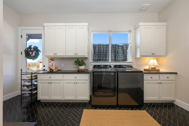 laundry room with cabinets, separate washer and dryer, and a healthy amount of sunlight