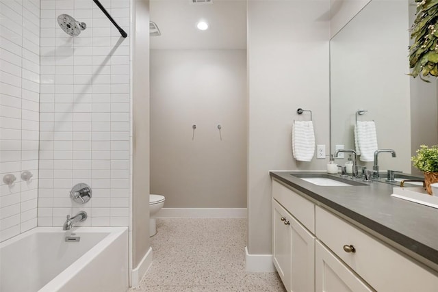 full bathroom with tiled shower / bath, vanity, and toilet