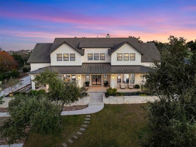 back house at dusk featuring a yard