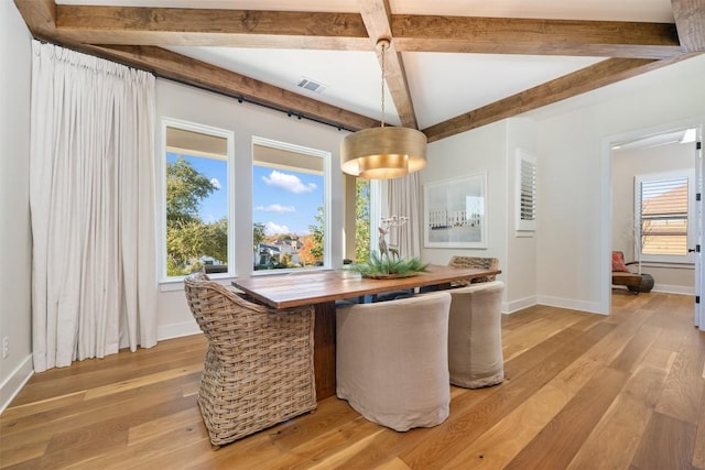 dining room with beam ceiling and light wood-type flooring