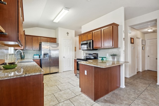 kitchen featuring light stone counters, sink, stainless steel appliances, and vaulted ceiling