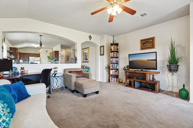 living room featuring ceiling fan, carpet floors, and vaulted ceiling