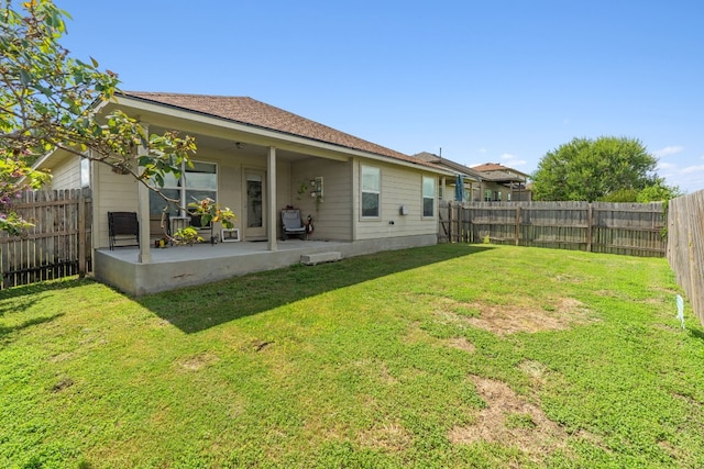 back of house with a patio area and a yard