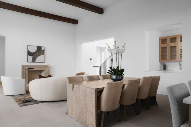 dining area with beam ceiling and a towering ceiling