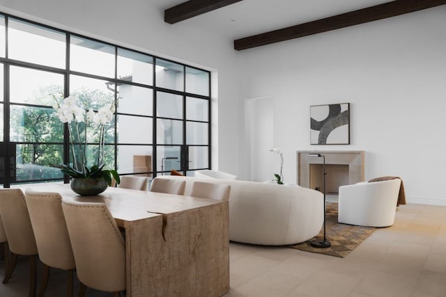 dining space featuring beamed ceiling and plenty of natural light