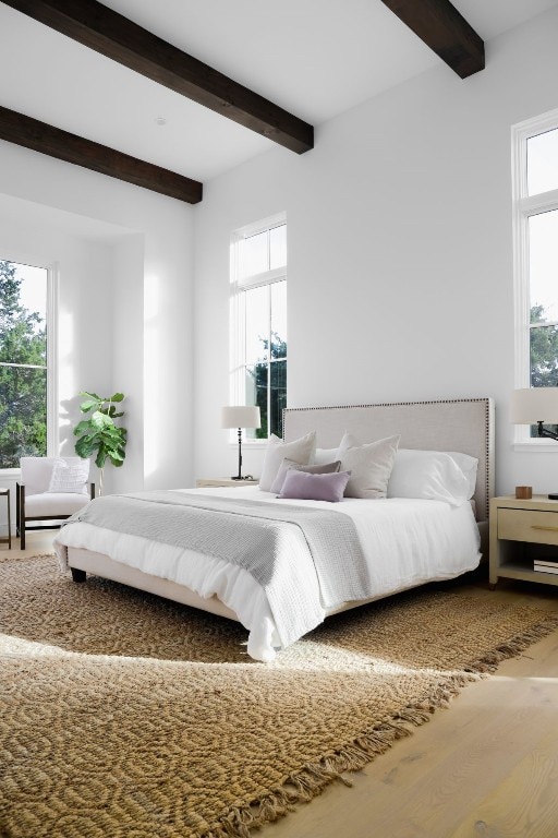 bedroom with beamed ceiling and hardwood / wood-style flooring