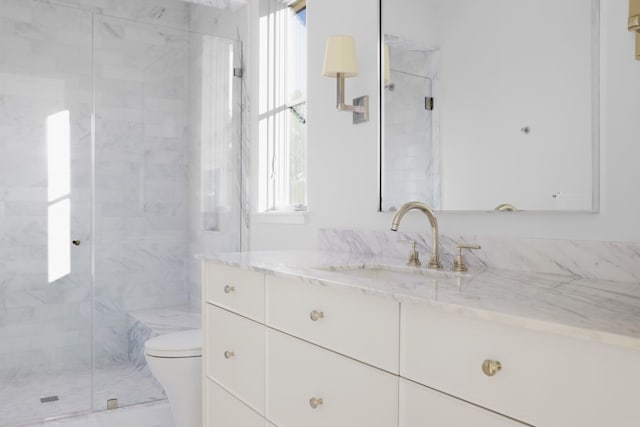 bathroom featuring vanity, an enclosed shower, and toilet