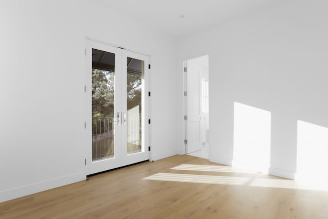 unfurnished room with french doors and light wood-type flooring