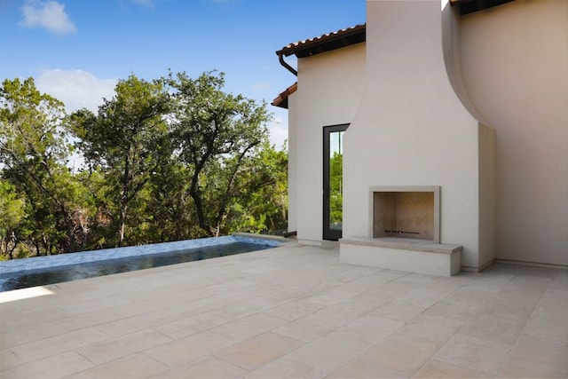 view of patio / terrace featuring an outdoor fireplace