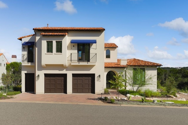 mediterranean / spanish house with a balcony and a garage