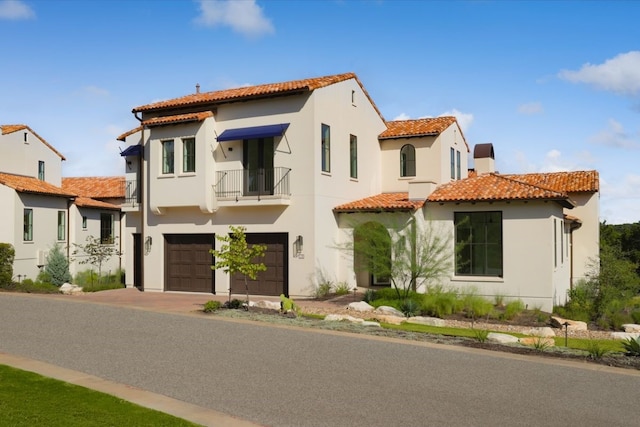 mediterranean / spanish-style house with a garage and a balcony