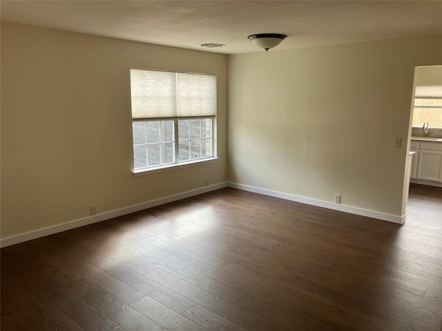 unfurnished room featuring dark hardwood / wood-style flooring and sink