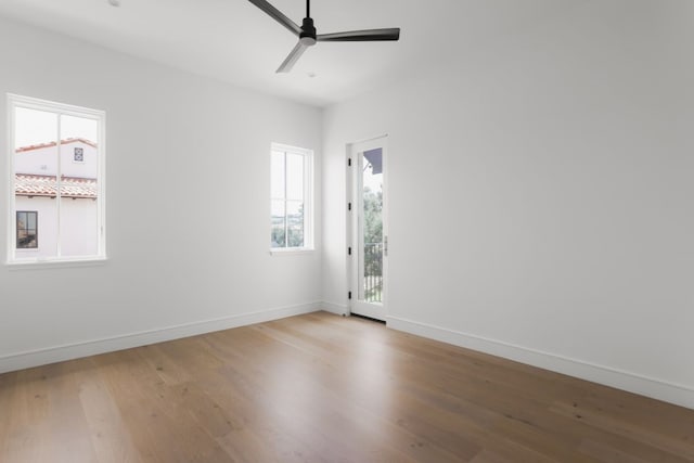 unfurnished room featuring a ceiling fan, baseboards, and wood finished floors