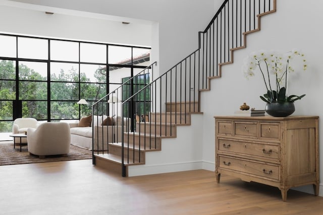 staircase with baseboards and wood finished floors