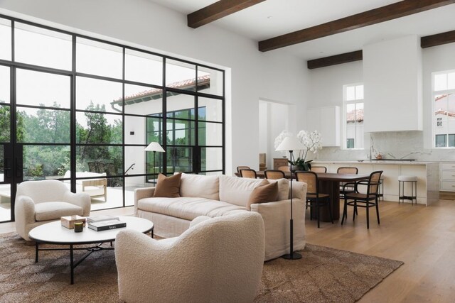 living room featuring light wood-type flooring and beamed ceiling