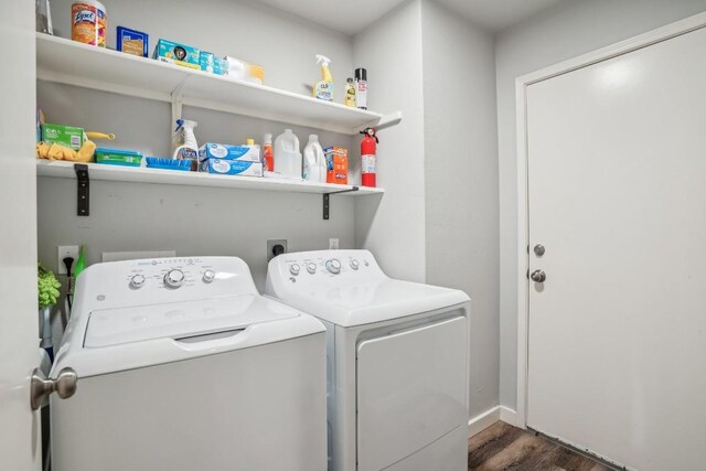 laundry area with dark hardwood / wood-style flooring and washer and dryer