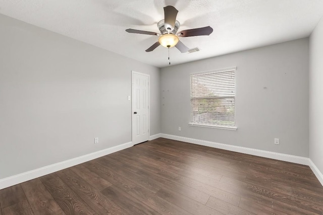 empty room with dark hardwood / wood-style flooring and ceiling fan