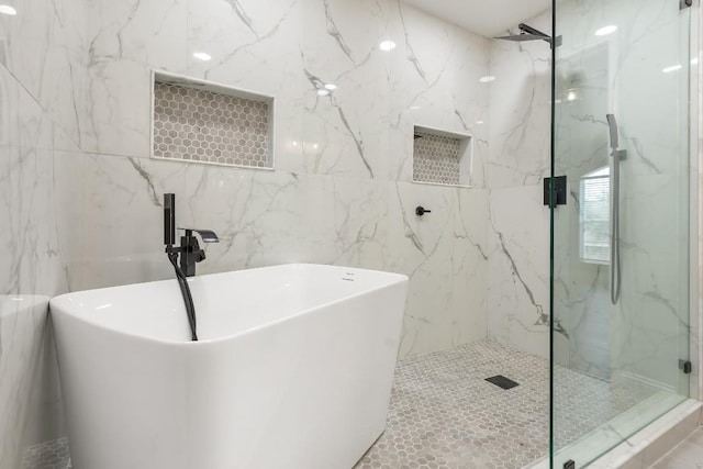 bathroom with tile walls and independent shower and bath