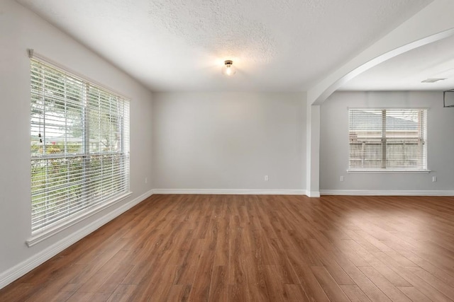 spare room with hardwood / wood-style floors and a textured ceiling