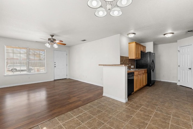 kitchen featuring black appliances, ceiling fan with notable chandelier, sink, decorative backsplash, and dark hardwood / wood-style flooring