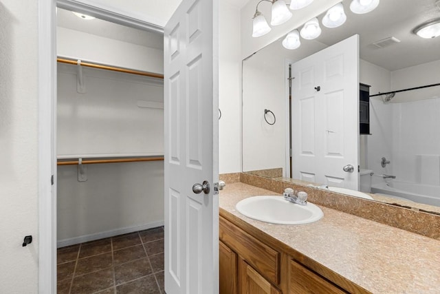 bathroom featuring tile patterned floors, vanity, and  shower combination