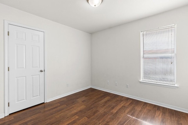 unfurnished room with dark wood-type flooring