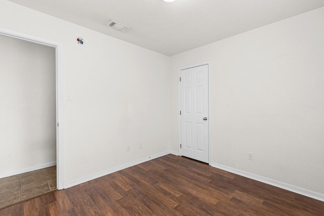 empty room with dark wood-type flooring