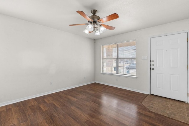 foyer entrance with ceiling fan and dark wood-type flooring