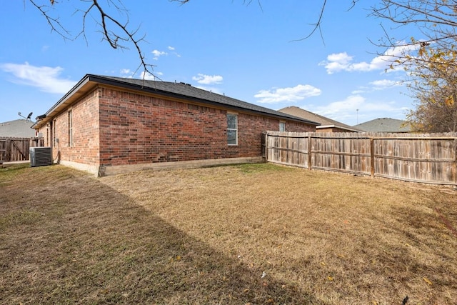 back of house featuring a lawn and central AC