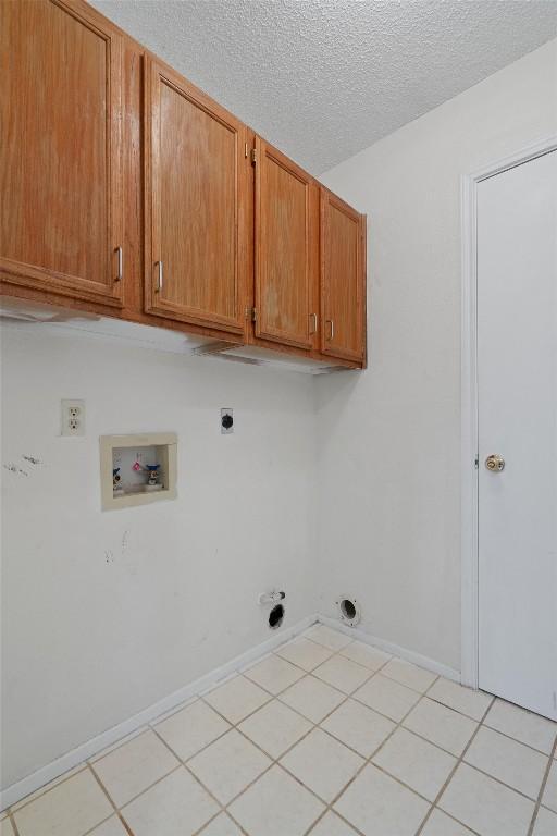 laundry room with hookup for a washing machine, light tile patterned floors, cabinets, and hookup for an electric dryer