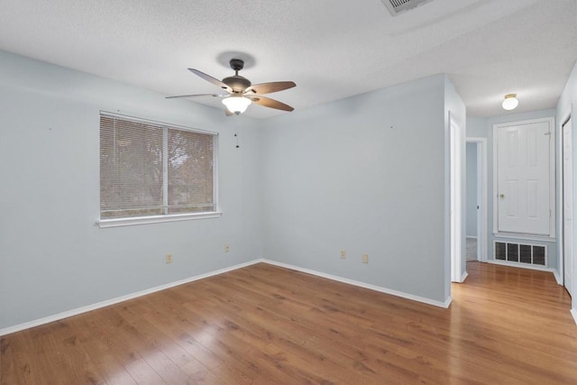 spare room with a textured ceiling, hardwood / wood-style flooring, and ceiling fan