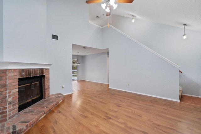 unfurnished living room with ceiling fan, wood-type flooring, a fireplace, and high vaulted ceiling