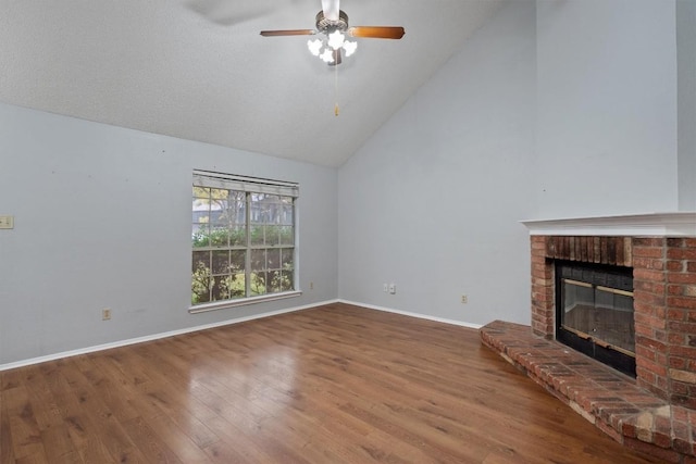 unfurnished living room with ceiling fan, a brick fireplace, high vaulted ceiling, hardwood / wood-style floors, and a textured ceiling