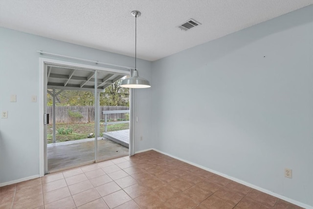 unfurnished dining area with light tile patterned floors and a textured ceiling