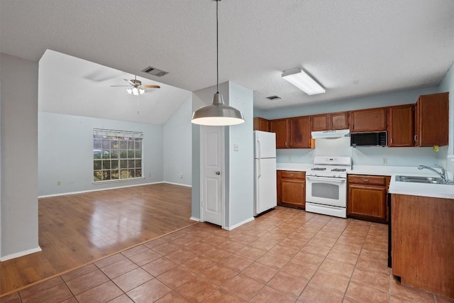 kitchen featuring white appliances, sink, pendant lighting, light hardwood / wood-style flooring, and lofted ceiling