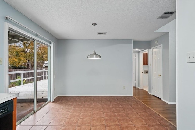 unfurnished dining area with light tile patterned floors and a textured ceiling