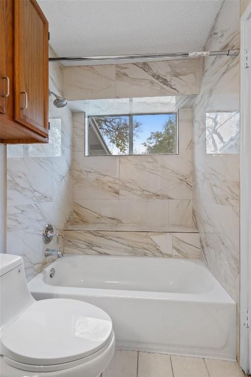 bathroom featuring tile patterned floors, tiled shower / bath, a textured ceiling, and toilet