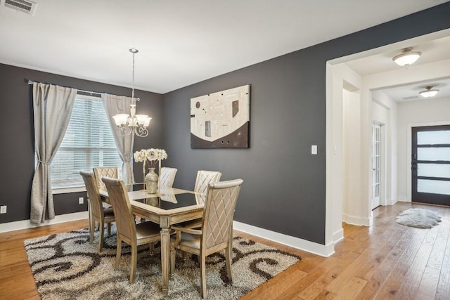 dining area featuring a notable chandelier and light hardwood / wood-style flooring